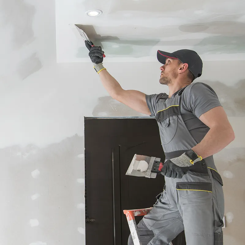 Interior-Remodeling Worker Installing and Spackling Sheetrock | In and Out Flooring